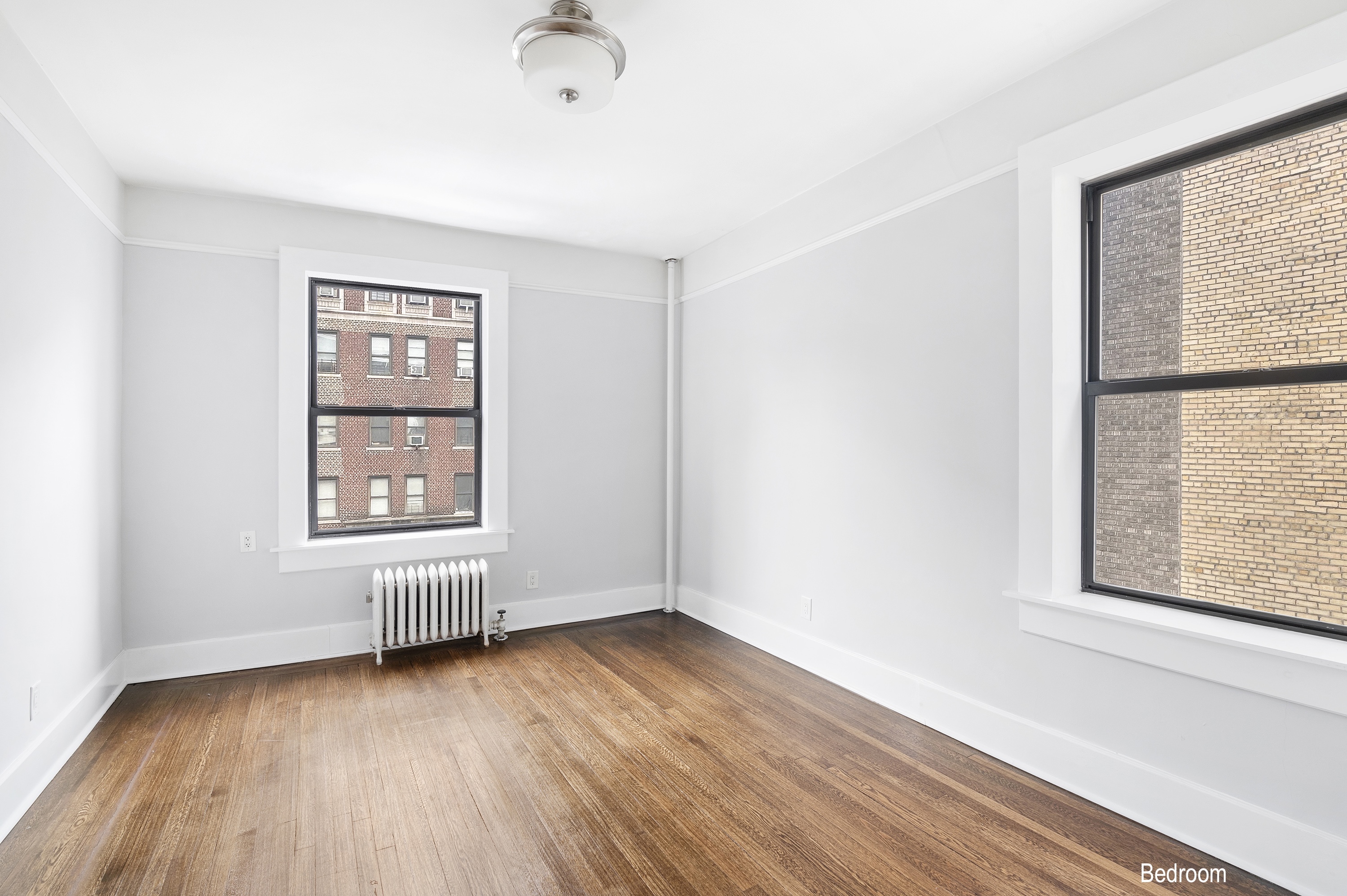 371 Fort Washington Avenue, Unit 4B Manhattan, NY 10033 - Photo 12 of 14 an empty room with wooden floor and windows