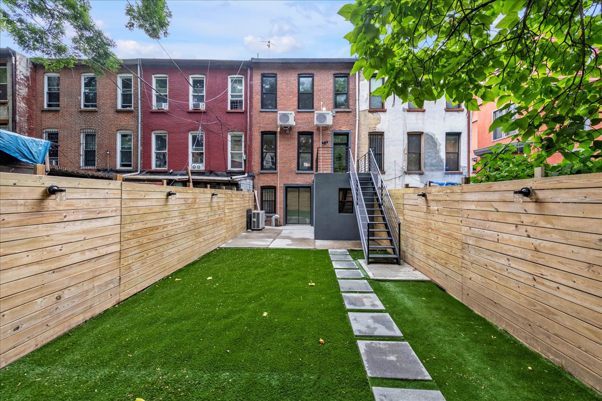 448 Halsey Street, Unit 1 Brooklyn, NY 11233 - Photo 19 of 22 a view of a brick house with a yard