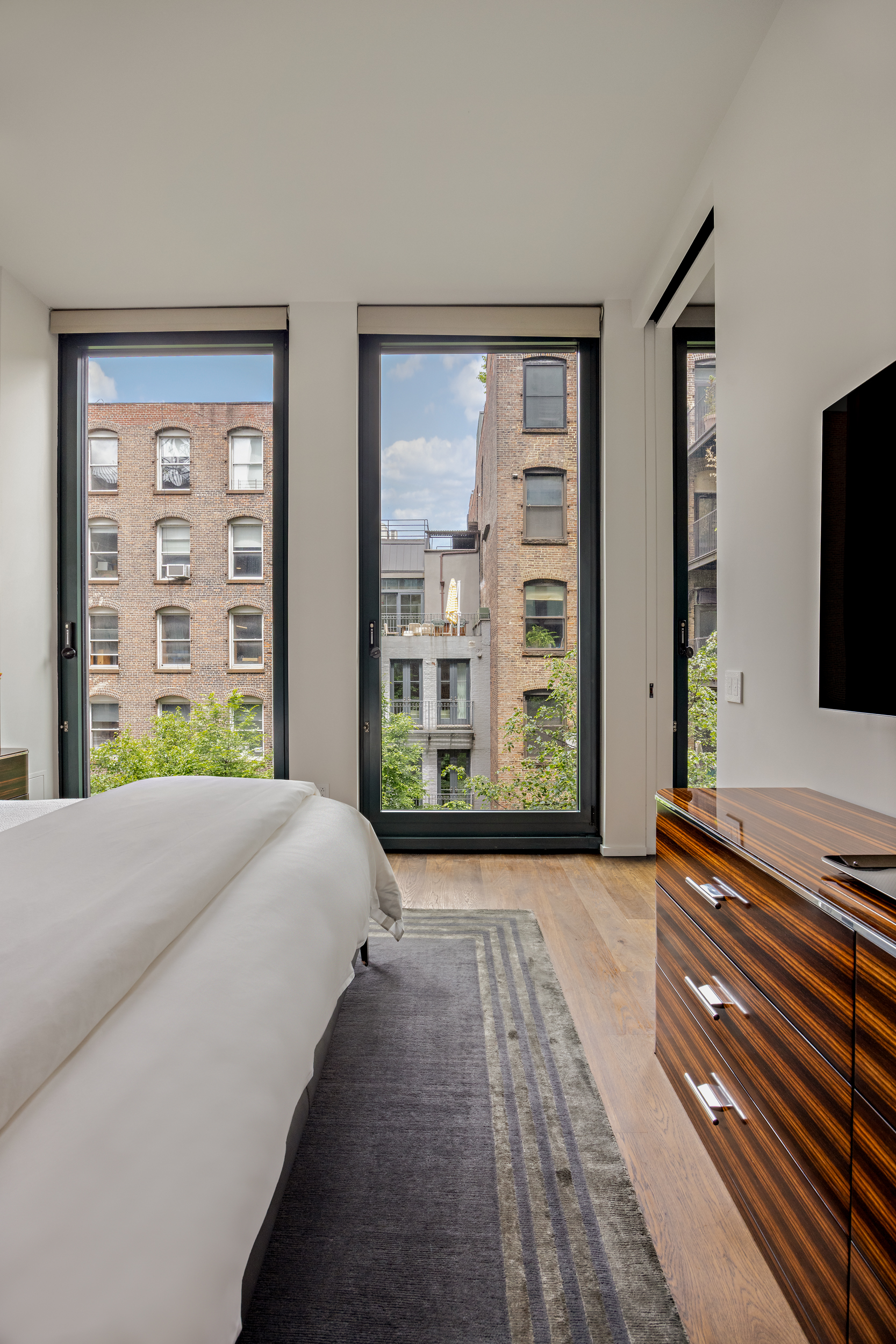 40 Bond Street, Unit 6D Manhattan, NY 10012 - Photo 16 of 23 a spacious bedroom with a large bed and a flat tv screen