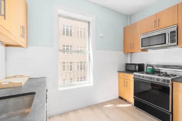 a kitchen with stainless steel appliances a stove a sink and a microwave