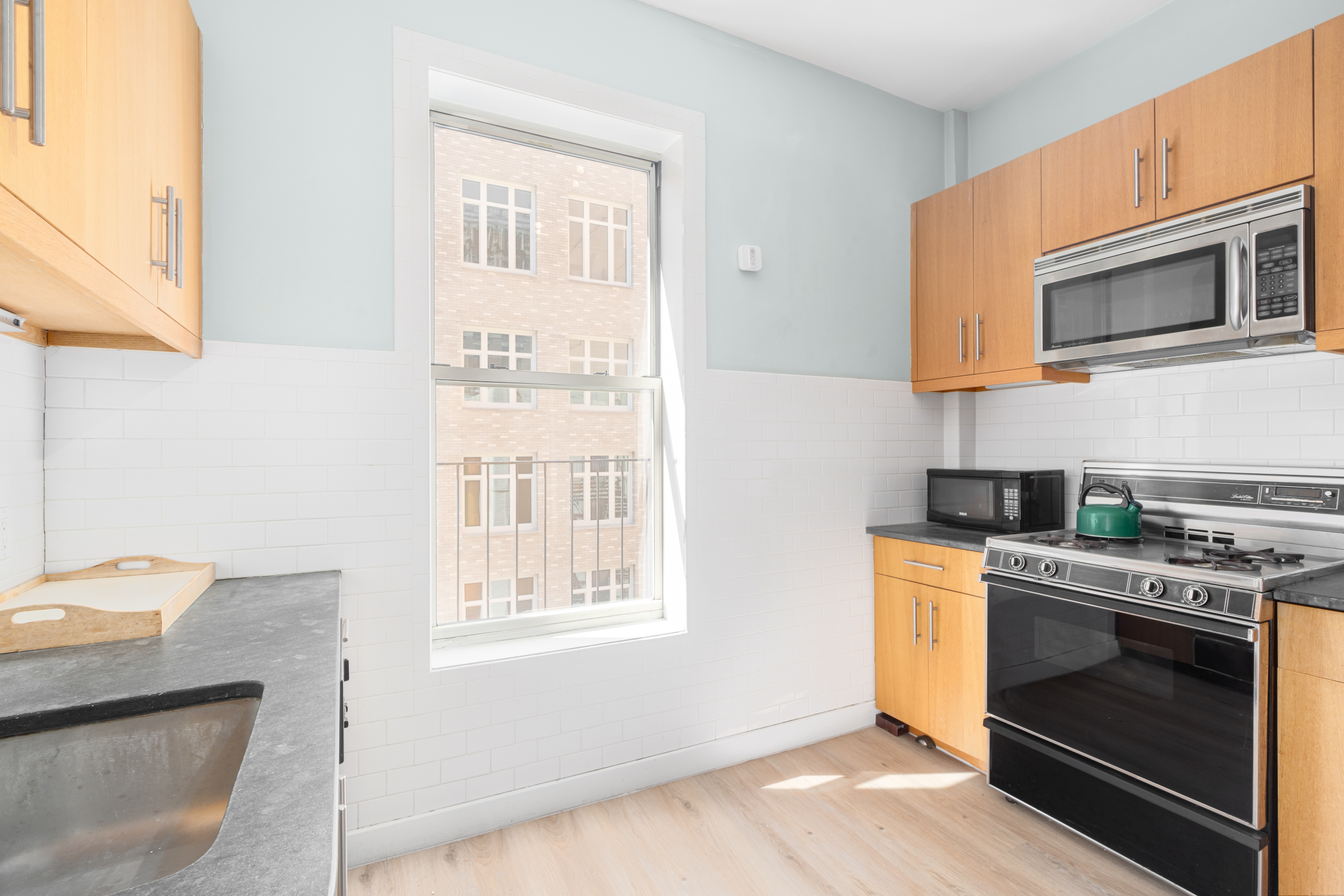 212 West 85th Street, Unit 5W Manhattan, NY 10024 - Photo 3 of 11 a kitchen with stainless steel appliances a stove a sink and a microwave