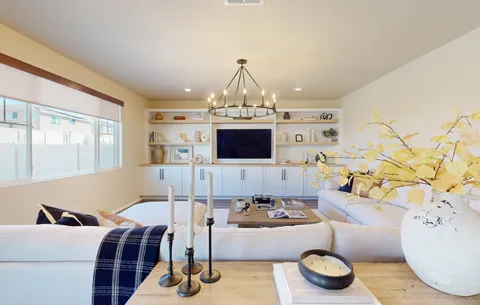 a living room with furniture a chandelier and a flat screen tv