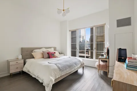 a bedroom with a bed and a wooden floor