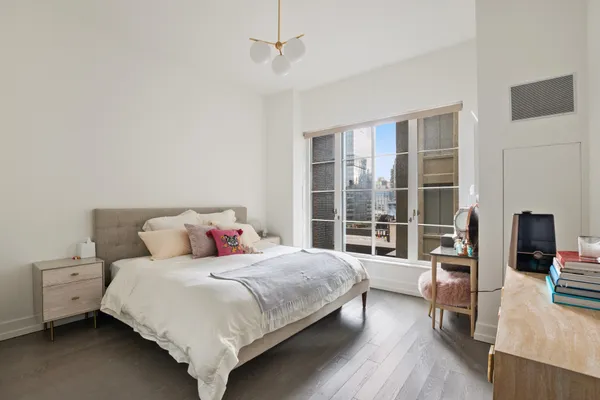 a bedroom with a bed and a wooden floor