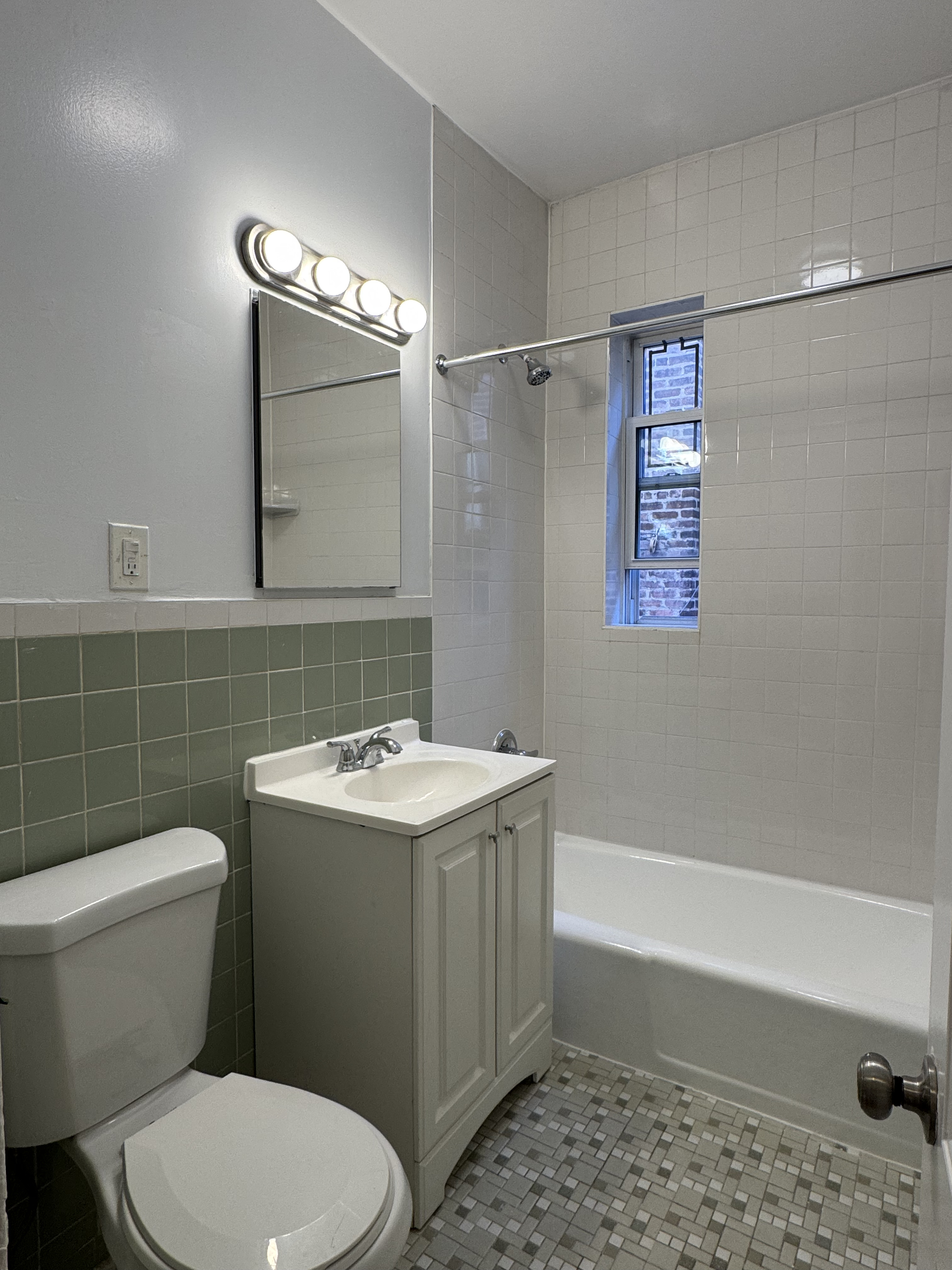 191-13 42nd Avenue, Unit 1F Queens, NY 11358 - Photo 6 of 6 a bathroom with a sink a toilet and shower