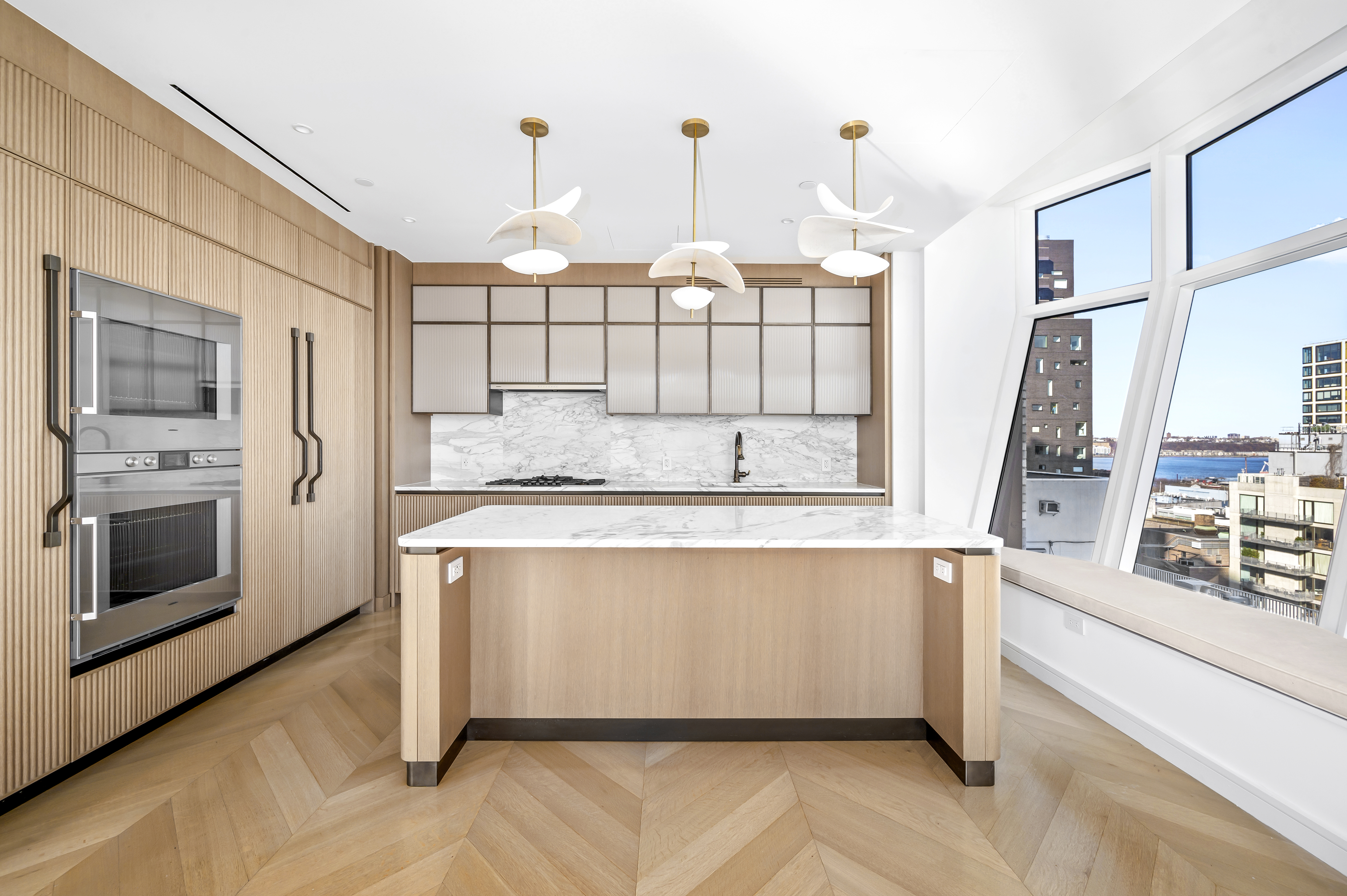 515 West 18th Street, Unit 1401 Manhattan, NY 10011 - Photo 2 of 12 a large kitchen with kitchen island granite countertop a stove a sink and white cabinets with wooden floor