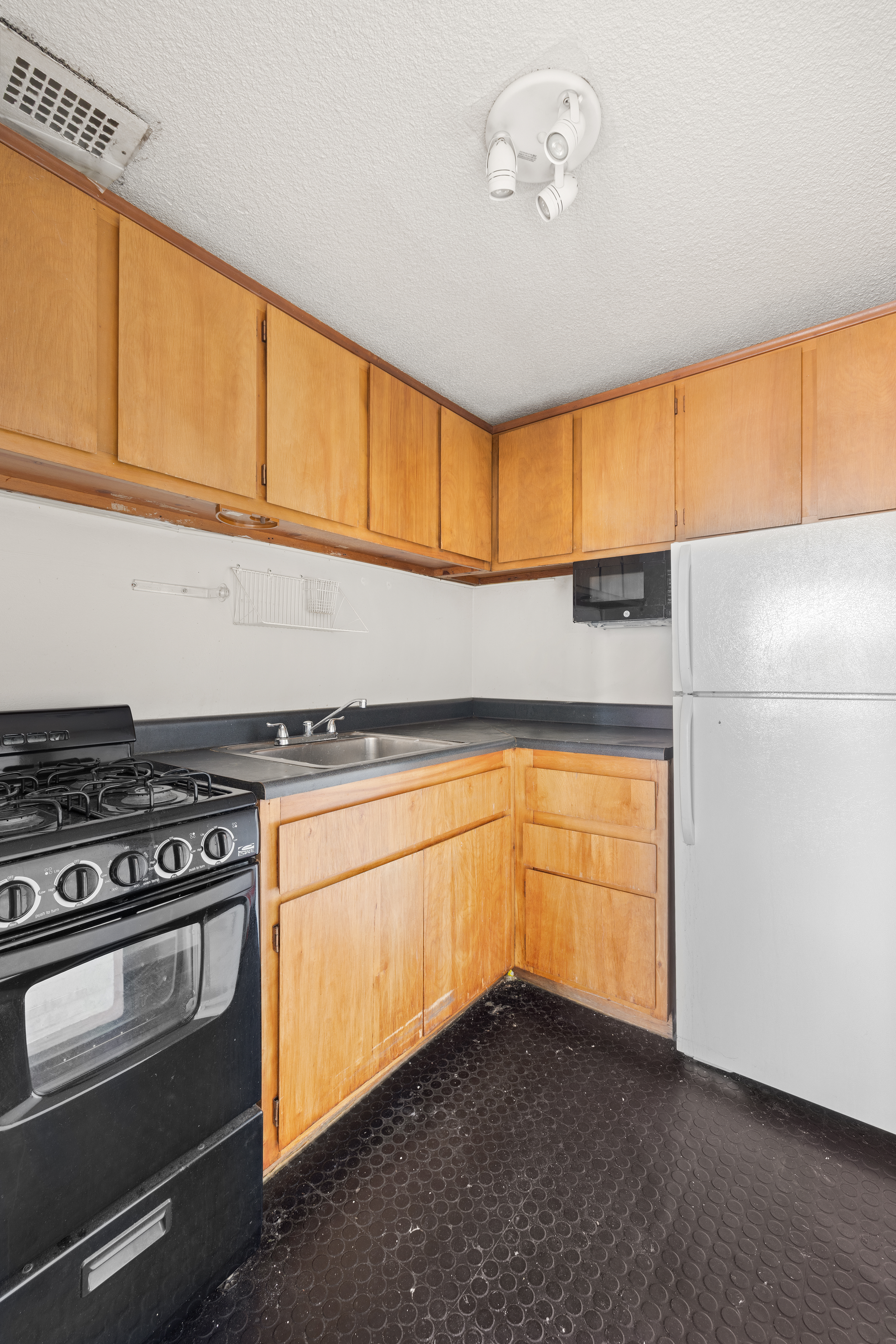 180 Park Row, Unit 25E Manhattan, NY 10007 - Photo 6 of 11 a kitchen with stainless steel appliances granite countertop a stove a sink and a refrigerator