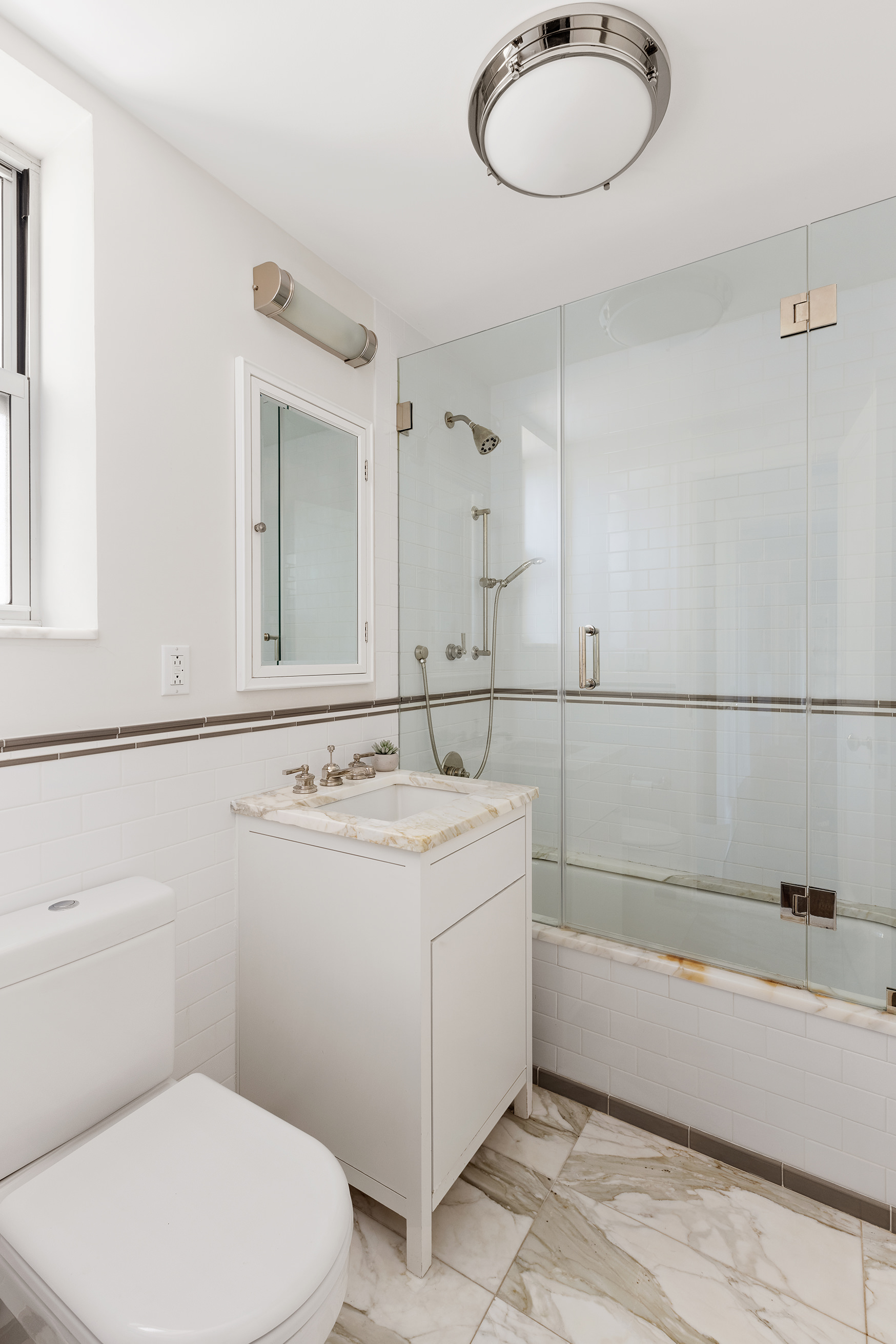165 West 91st Street, Unit 9AB Manhattan, NY 10024 - Photo 12 of 24 a bathroom with a sink a toilet and mirror