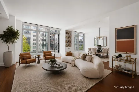 a living room with furniture and floor to ceiling windows