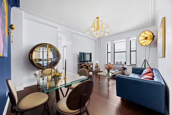 a living room with furniture a rug and a mirror