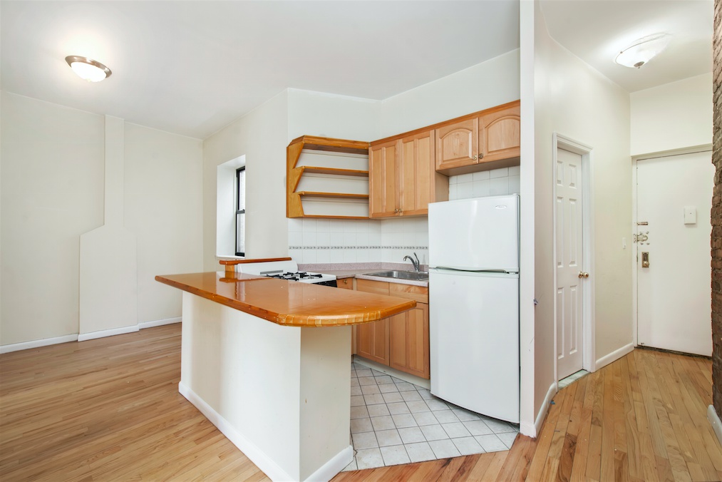 309 East 95th Street, Unit 27 Manhattan, NY 10128 - Photo 4 of 8 a kitchen that has a sink and a refrigerator