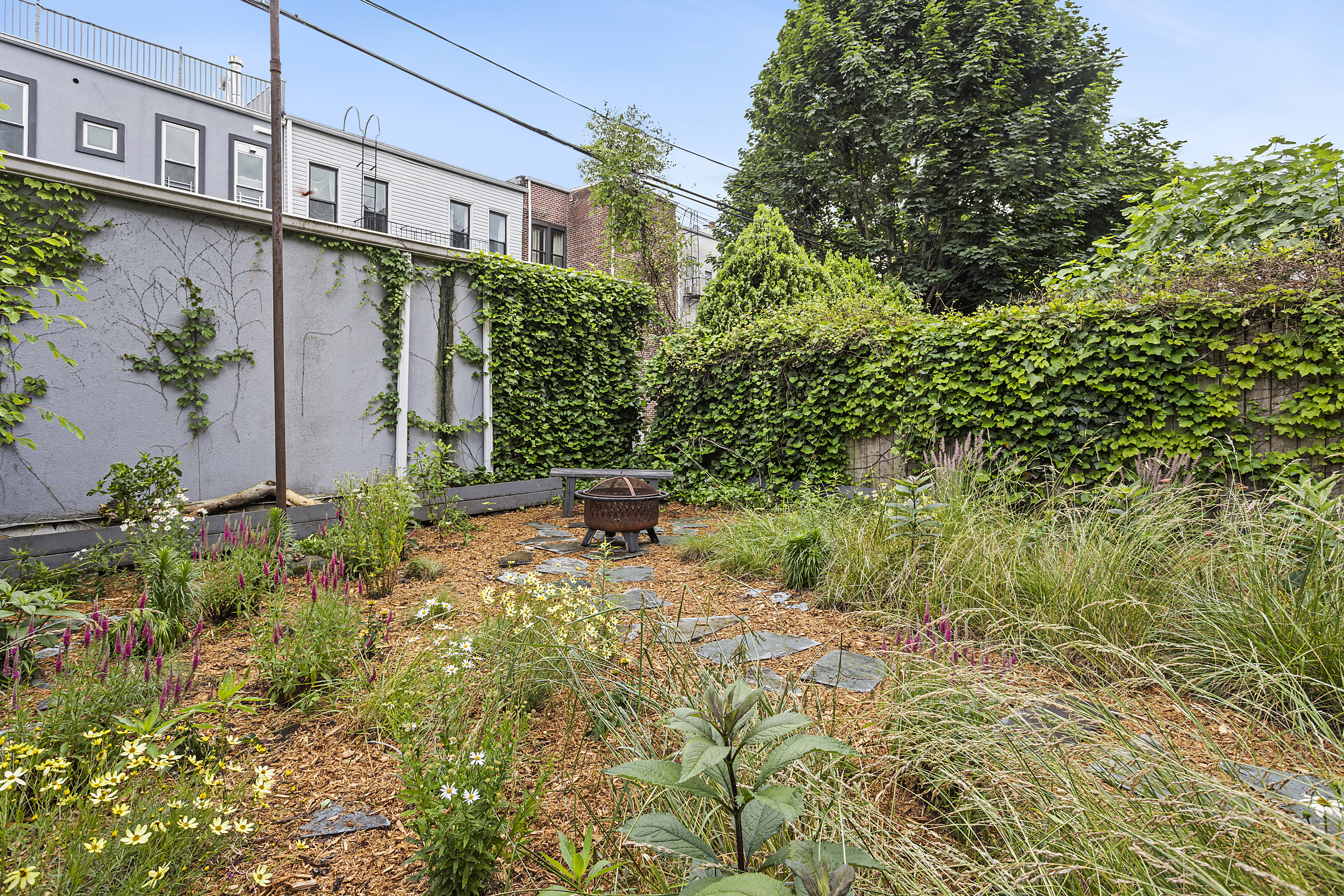 768 Hart Street, Unit 1 Brooklyn, NY 11237 - Photo 17 of 18 a backyard of a house with a yard and outdoor seating