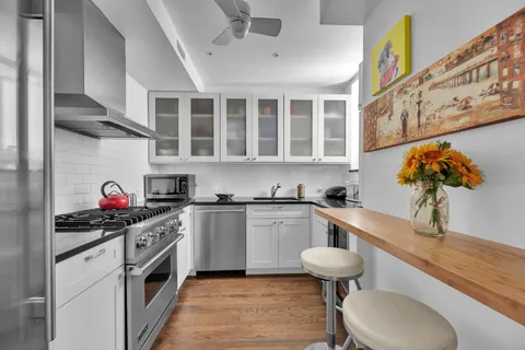 a kitchen with stainless steel appliances a stove a sink and a refrigerator