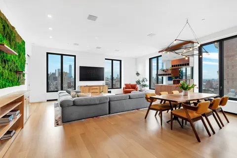 a living room with furniture a flat screen tv and a large window