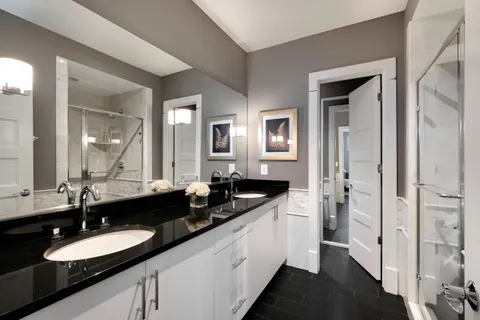 a en suite bathroom with a granite countertop sink and a mirror