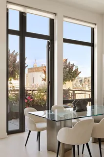 a view of a dining room with furniture large windows and wooden floor