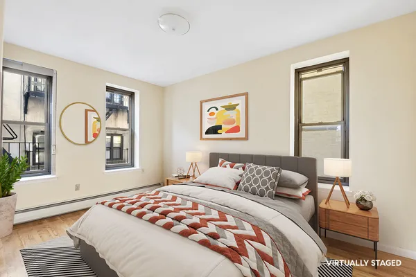 a bedroom with a bed mirror and window