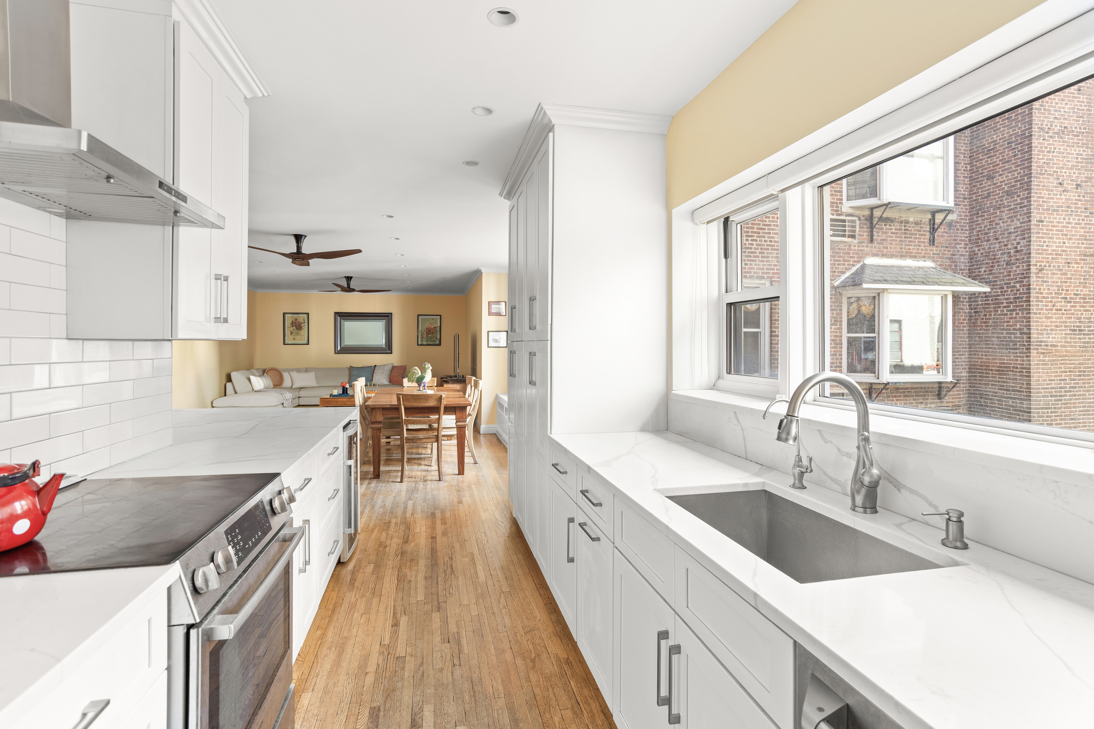 161 East 90th Street, Unit 5C Manhattan, NY 10128 - Photo 2 of 14 a kitchen with granite countertop a sink stove top oven and cabinets
