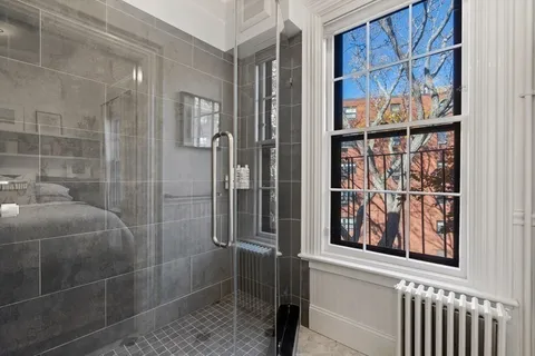 a bathroom with a shower and a window