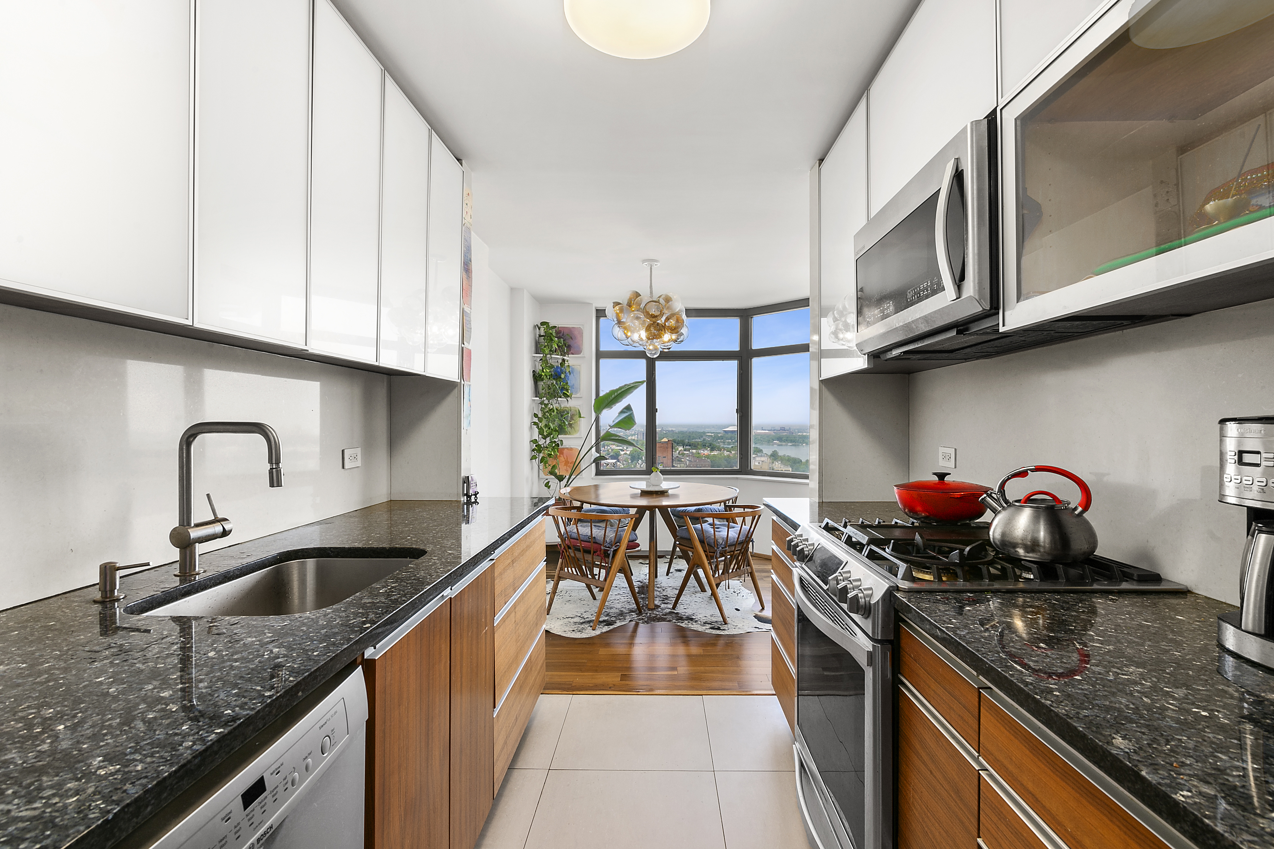 112-01 Queens Boulevard, Unit 18H Queens, NY 11375 - Photo 4 of 25 a kitchen with stainless steel appliances granite countertop a sink a stove and a wooden cabinets