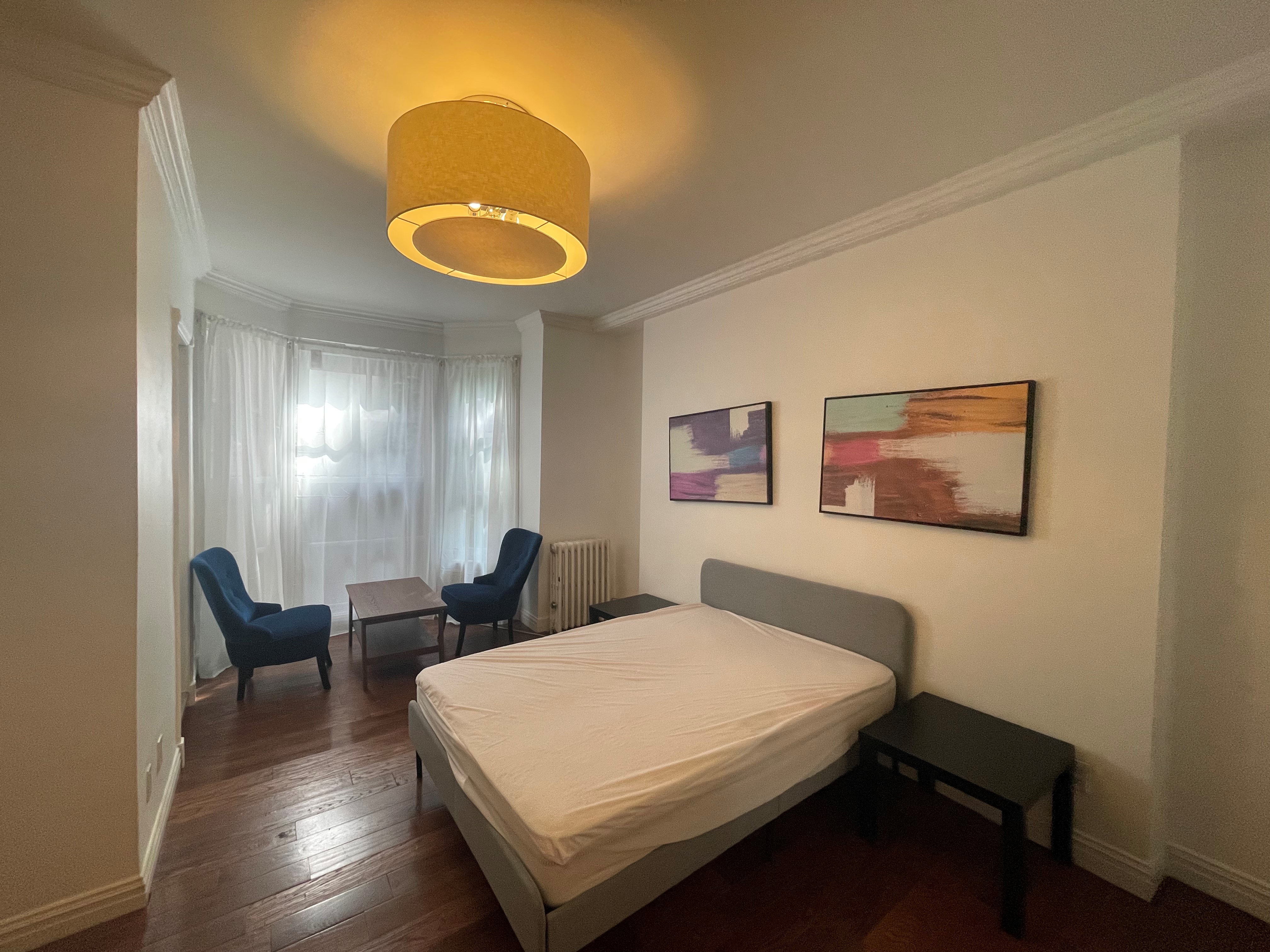 120 East 10th Street, Unit 1 Manhattan, NY 10003 - Photo 3 of 24 a bedroom with a bed and a lamp on dresser