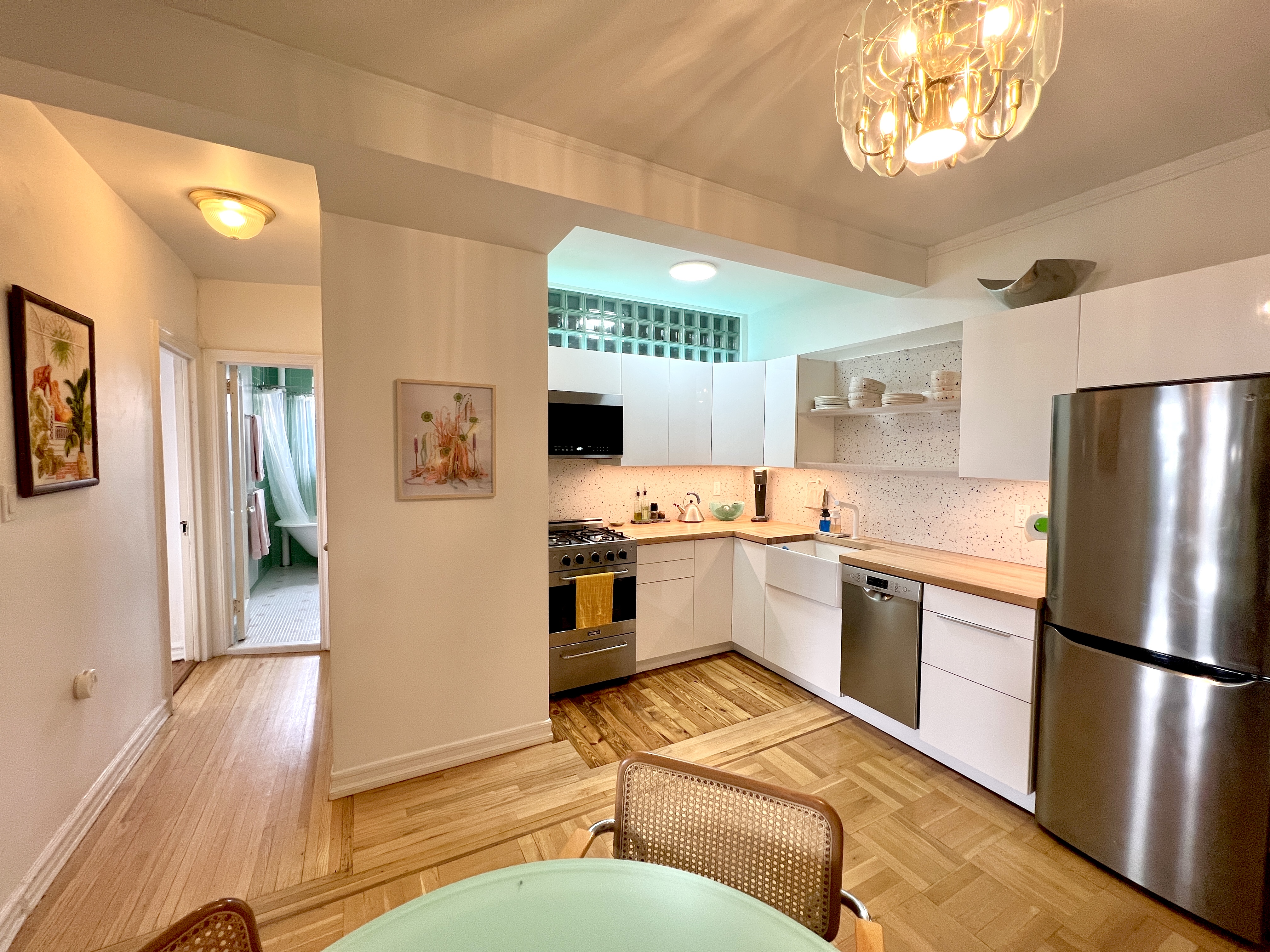909 East 29th Street, Unit 6F Brooklyn, NY 11210 - Photo 6 of 12 a kitchen with stainless steel appliances granite countertop a refrigerator a sink dishwasher a stove with wooden cabinets and floor