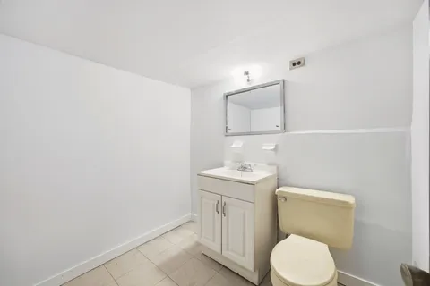 a bathroom with a toilet a sink and mirror