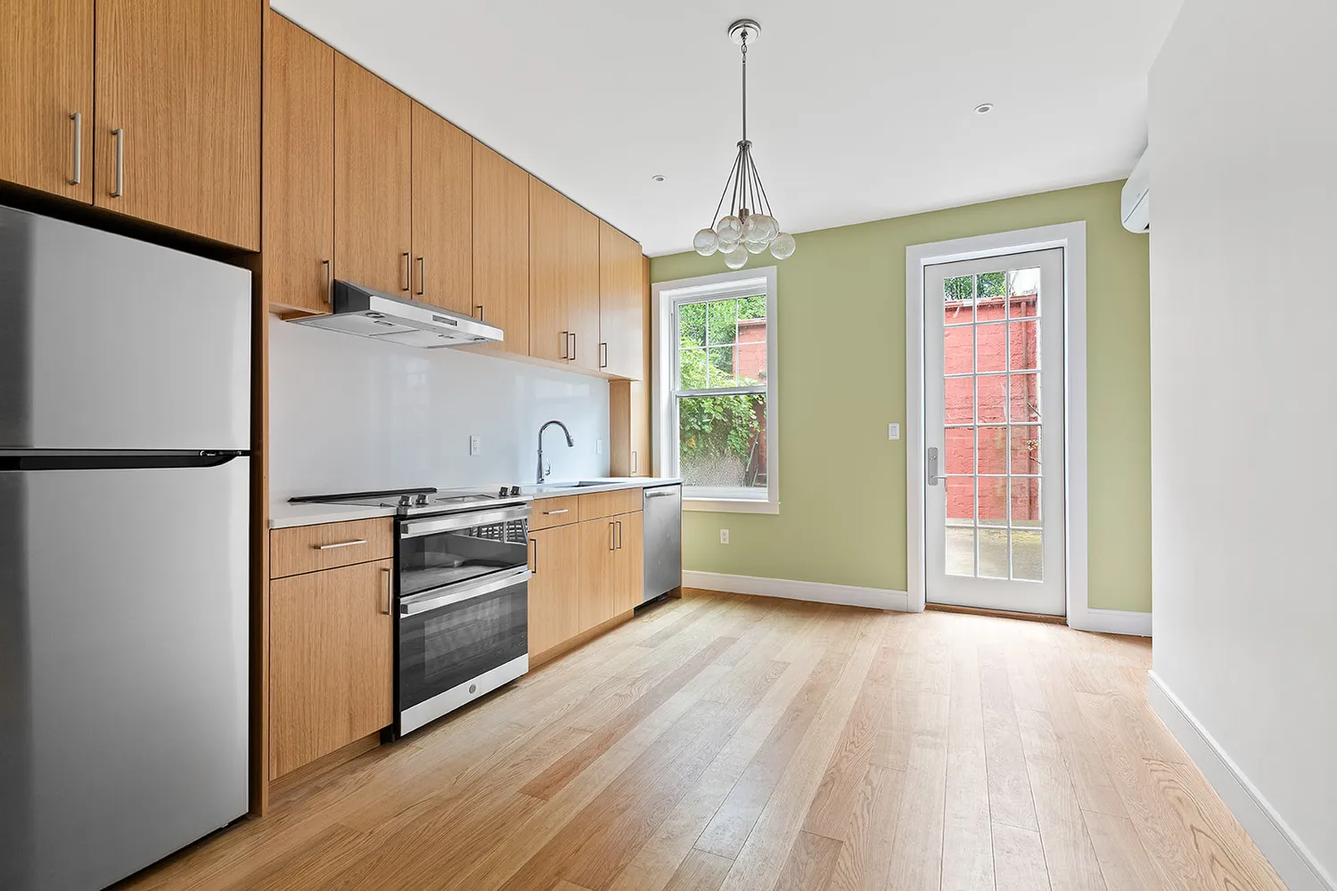 a kitchen with granite countertop stainless steel appliances a refrigerator cabinets and wooden floor