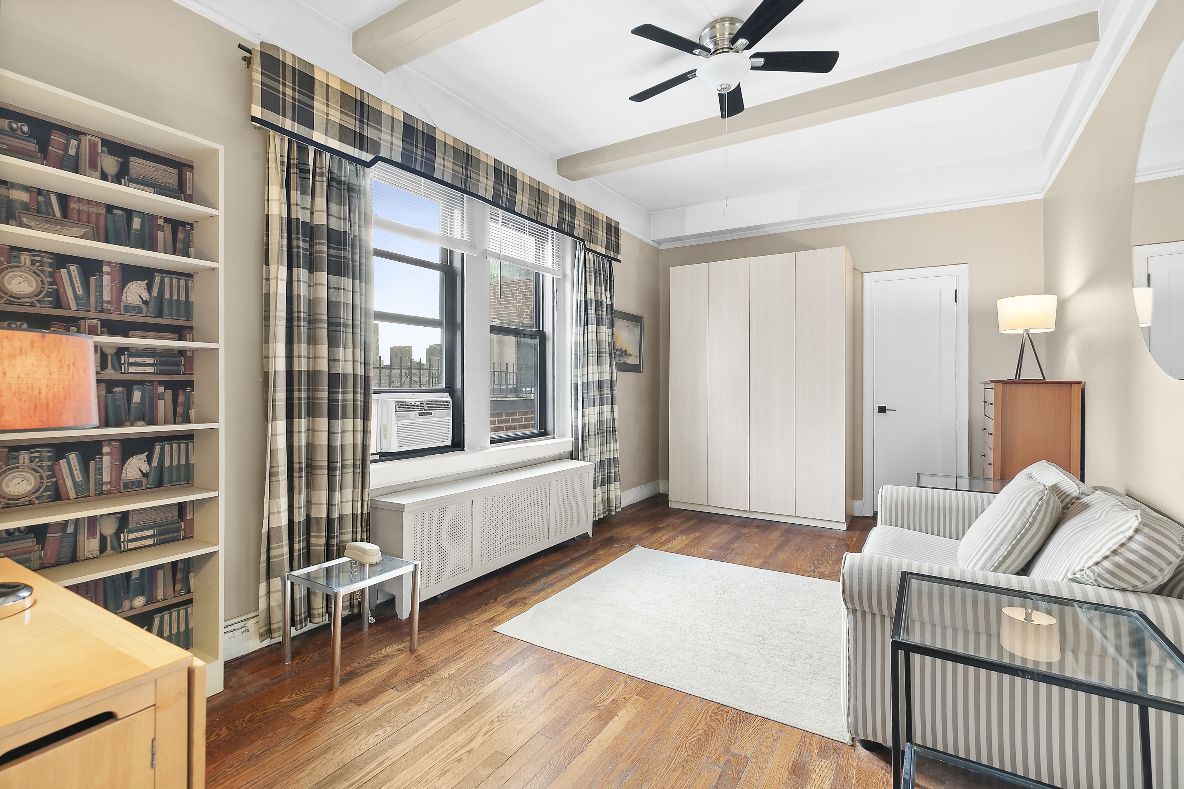 321 East 54th Street Manhattan, NY 10022 - Photo 1 of 5 a living room with furniture and a book shelf
