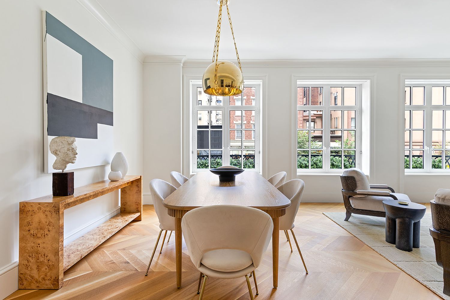 a dining room with wooden floor a chandelier a glass table and chairs