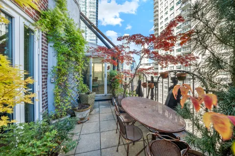 a view of a patio with table and chairs and potted plants