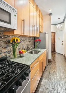 a kitchen with stainless steel appliances a sink stove and cabinets