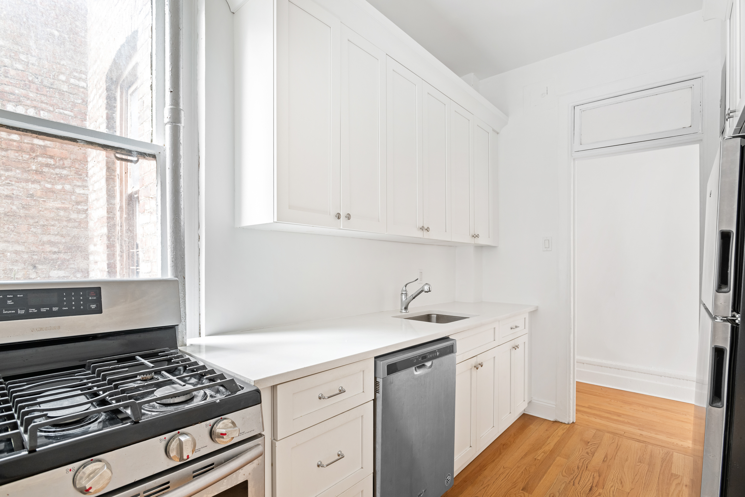 50 East 96th Street, Unit 5D Manhattan, NY 10128 - Photo 2 of 5 a kitchen with a sink stove and cabinets