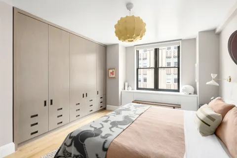 a bedroom with a large bed and a chandelier