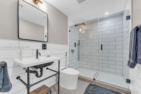 a bathroom with a sink toilet a mirror and shower