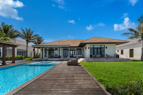 a front view of a house with swimming pool having outdoor seating