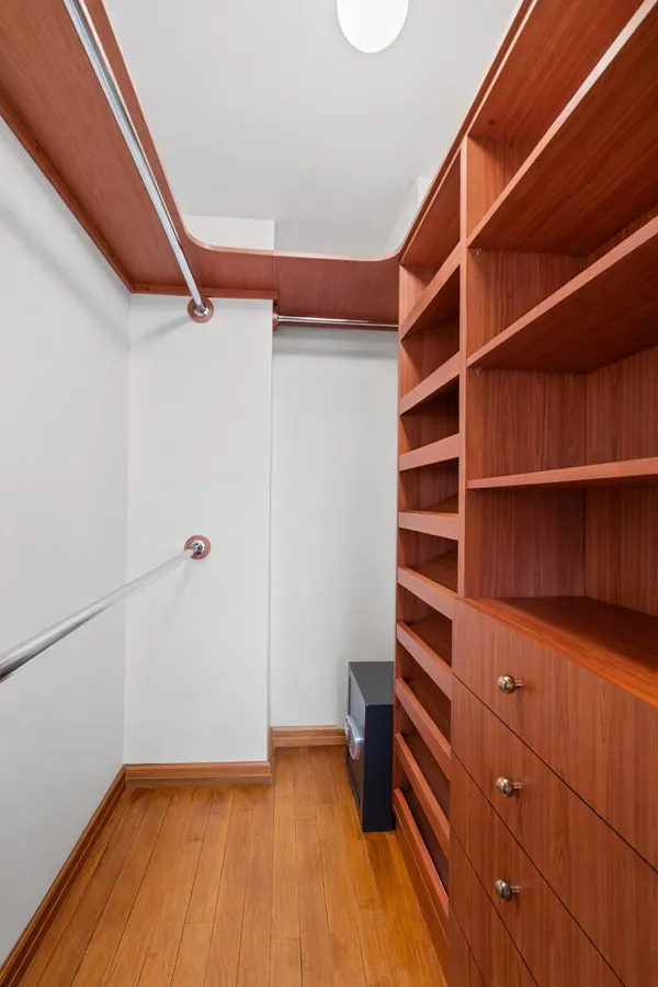 a view of walk in closet with empty racks