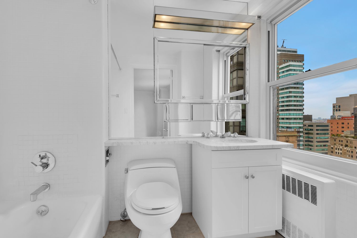 465 Park Avenue, Unit 26C Manhattan, NY 10022 - Photo 9 of 10 a bathroom with a granite countertop sink a toilet and shower