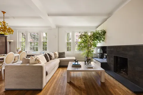 a living room with furniture fireplace and a large window