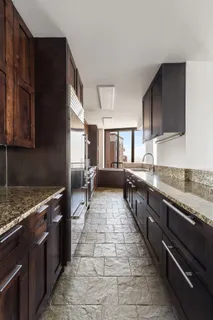 a large kitchen with granite countertop a stove top oven a sink dishwasher and cabinets