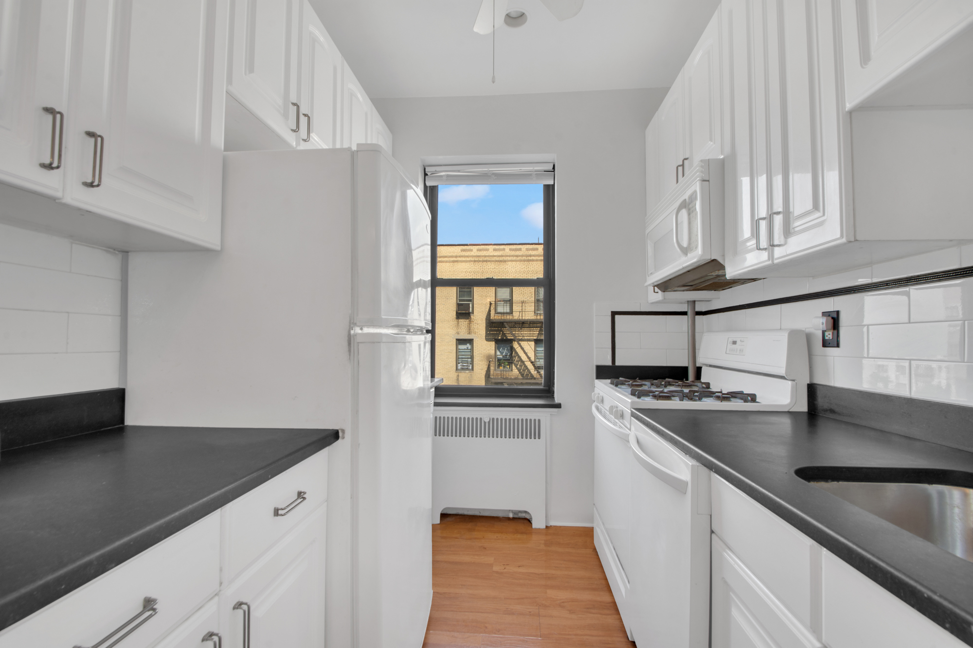 200 Pinehurst Avenue, Unit 5C Manhattan, NY 10033 - Photo 9 of 17 a kitchen with stainless steel appliances granite countertop a sink and a stove