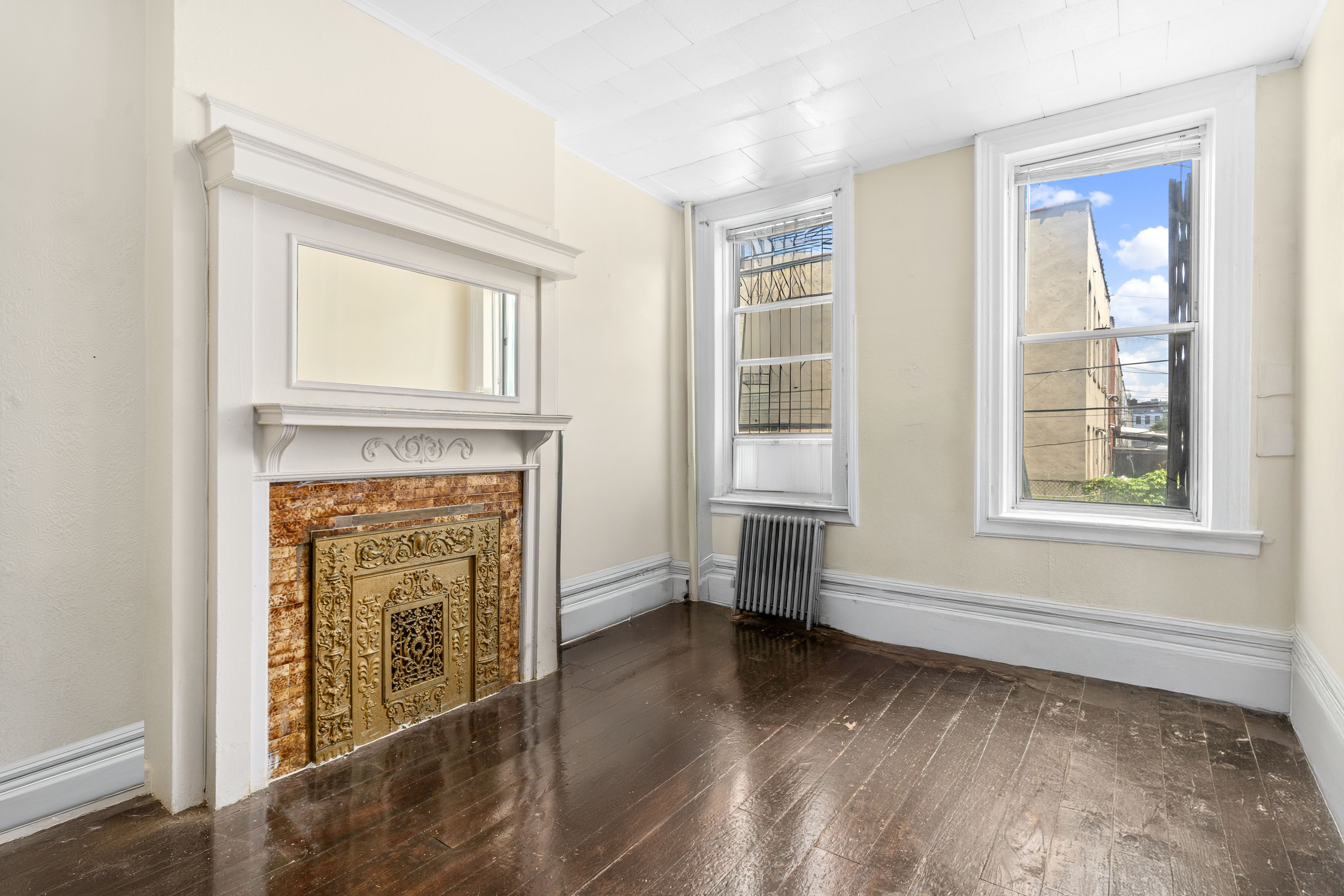 147 Schenectady Avenue Brooklyn, NY 11213 - Photo 4 of 9 a view of an empty room with a window and wooden floor