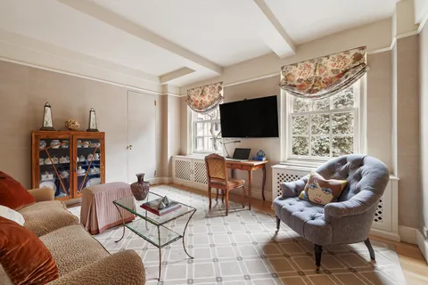 a living room with furniture a flat screen tv and a window