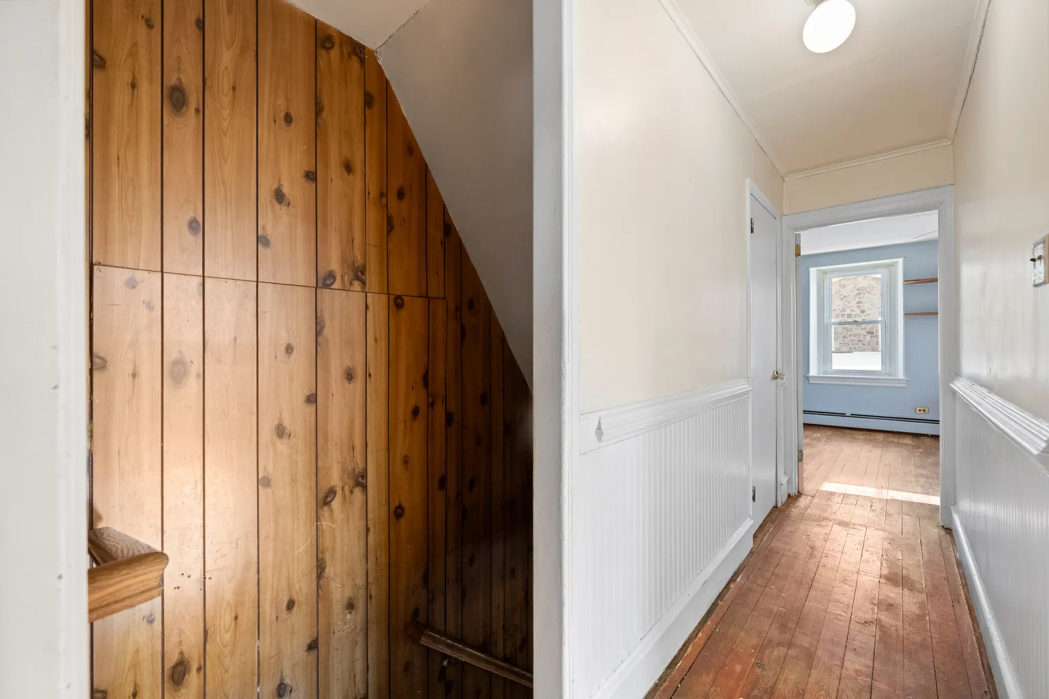a view of a hallway with wooden floor and staircase