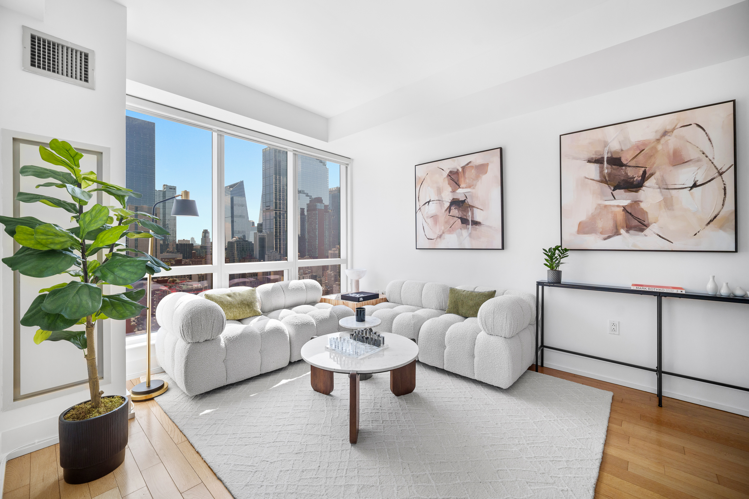 350 West 42nd Street, Unit 27K Manhattan, NY 10036 - Photo 3 of 18 a living room with furniture and a potted plant