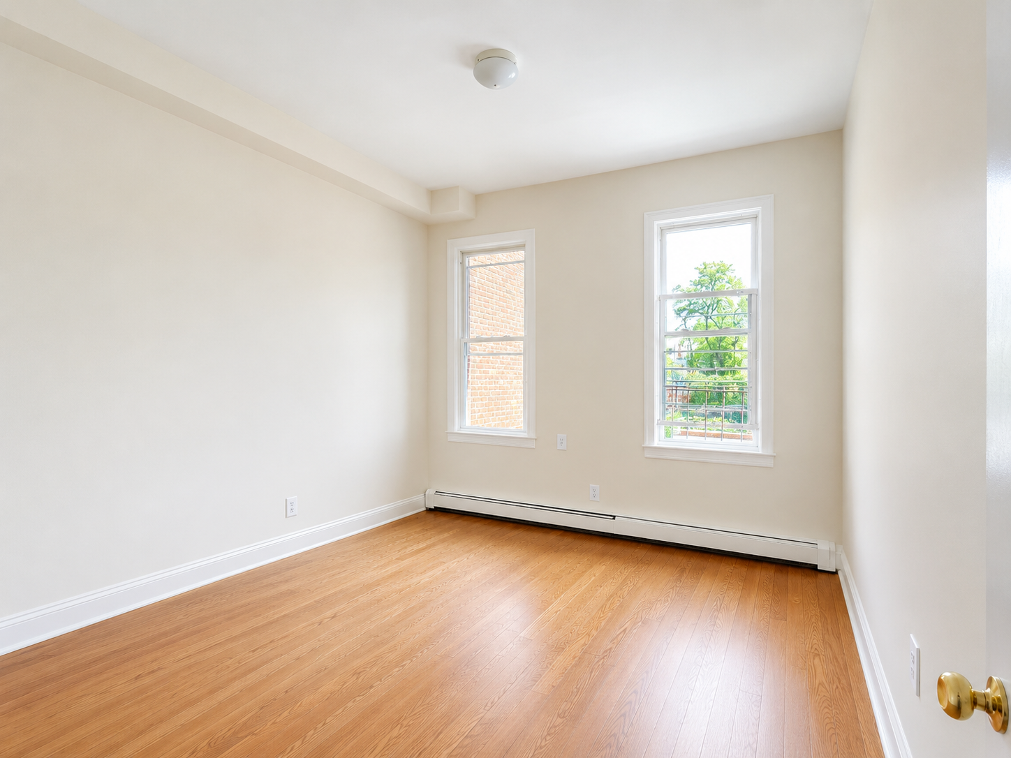 37-15 Broadway, Unit 2 Queens, NY 11103 - Photo 4 of 7 an empty room with wooden floor and windows