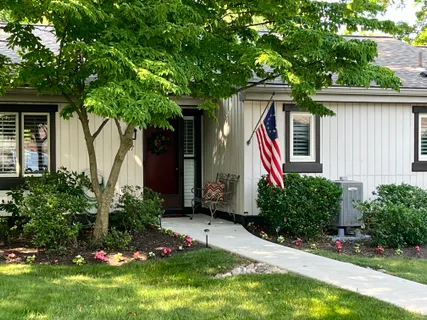 a front view of a house with a yard and potted plants