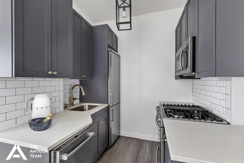 a kitchen with a sink a stove and cabinets