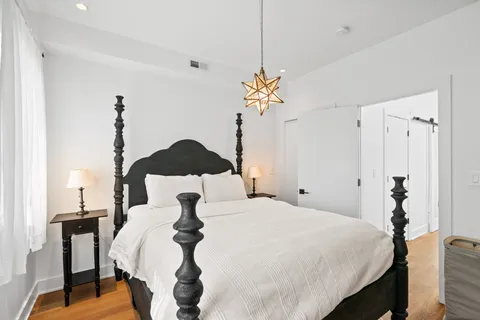 a bedroom with a bed and a chandelier
