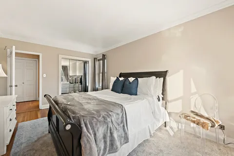 a bedroom with a bed and a dresser with rug